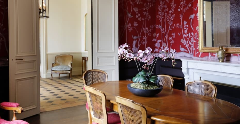 A dining table set with china, glassware and a floral centrepiece