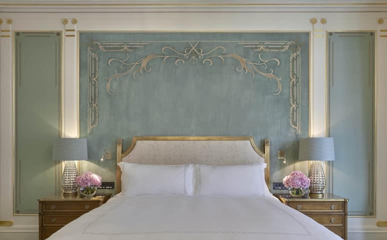 Prince Alexander suite bedroom with upholstered headboard and seafoam green wall panels