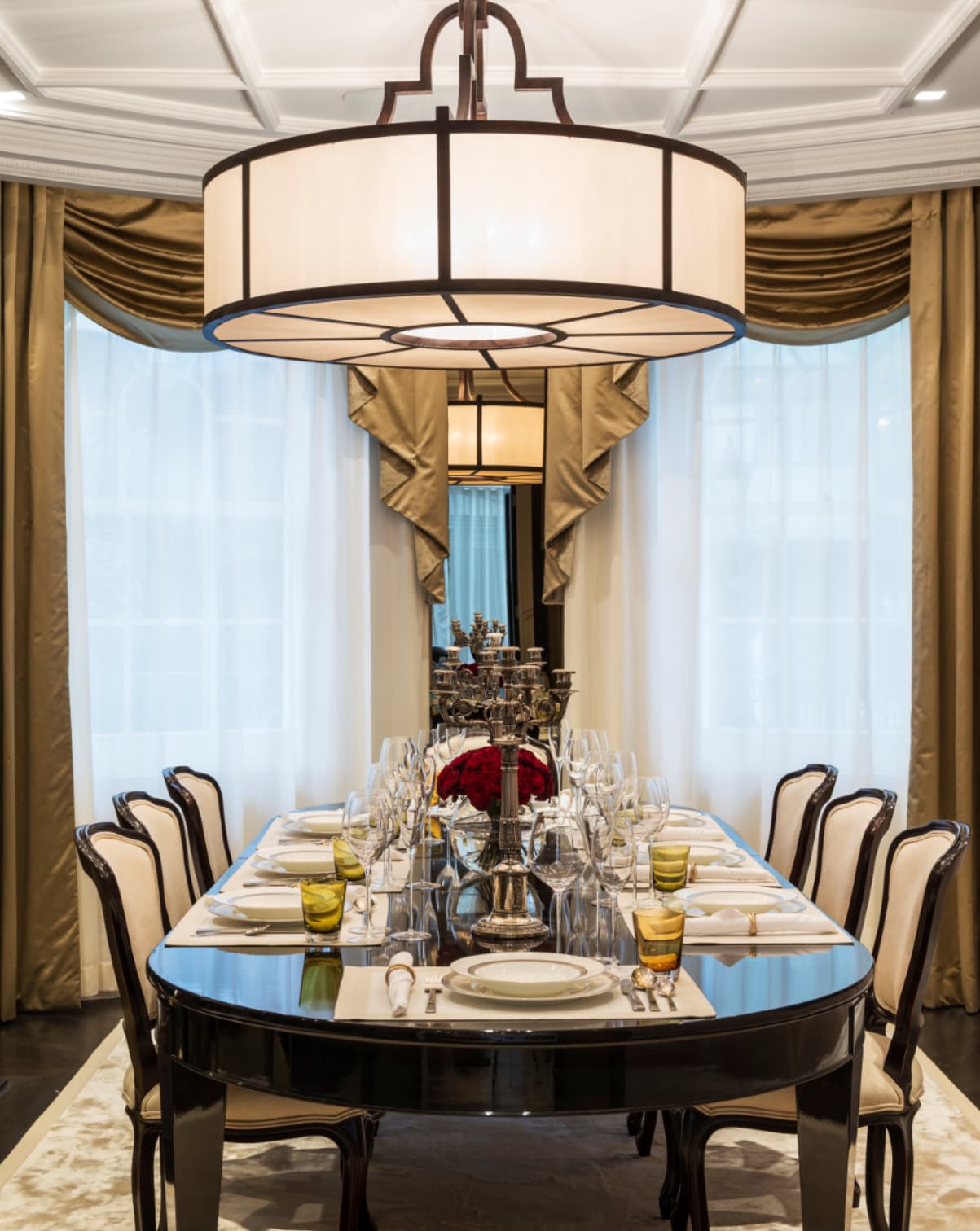 A dining table set with china, glassware and a floral centrepiece