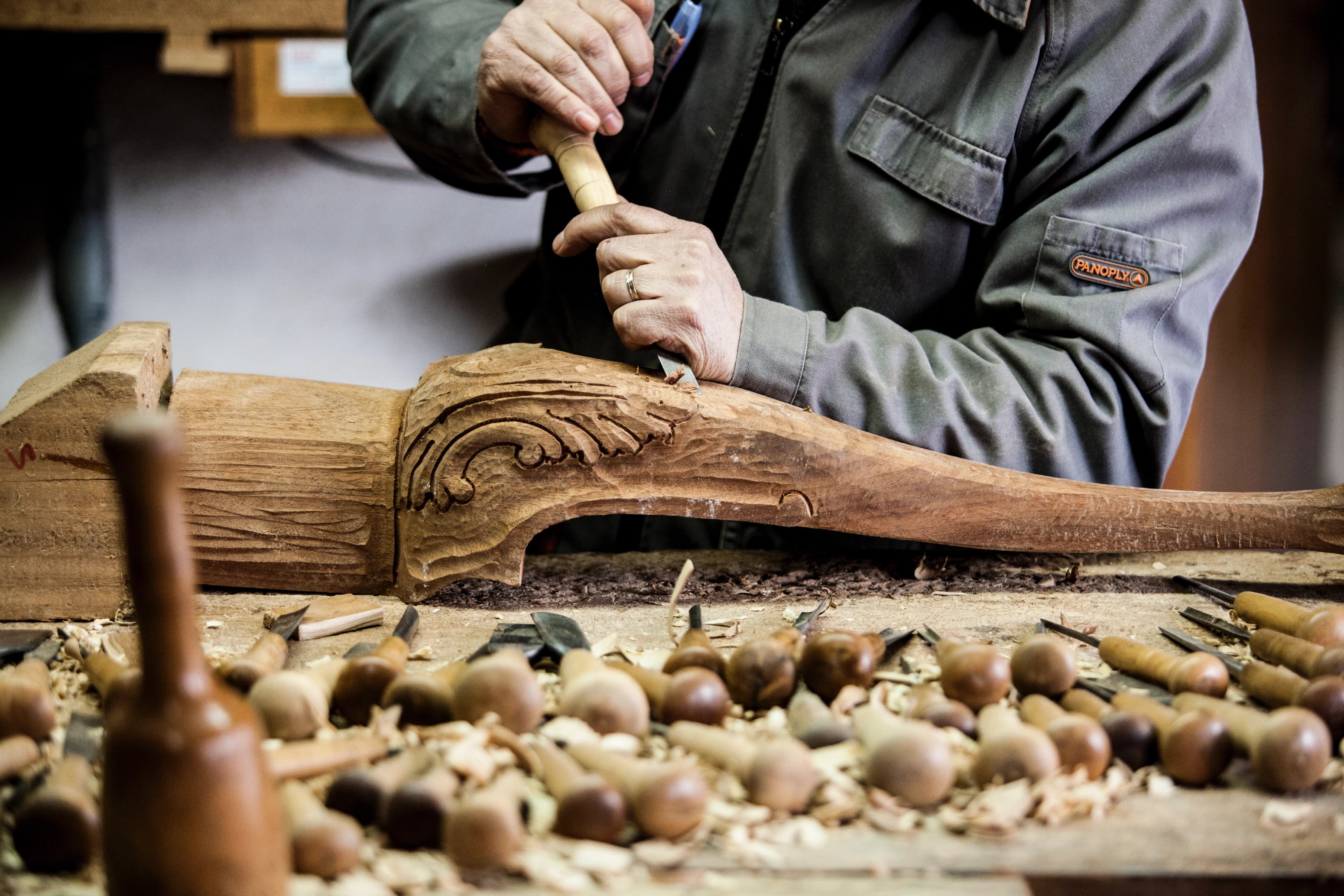 Craftsman carving an ornate wooden furniture leg