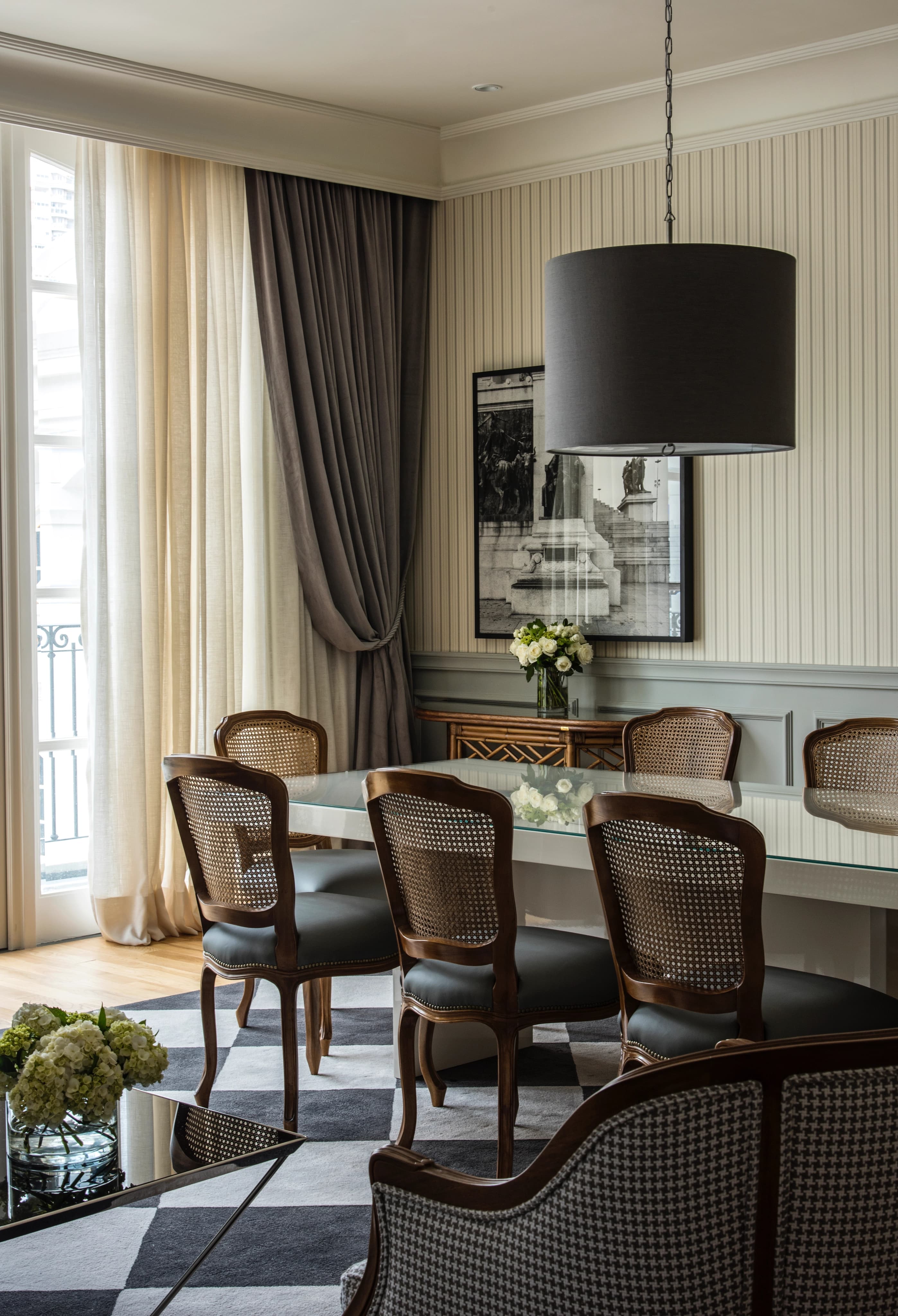 Dining room with a wooden table, cane chairs and a damask red wall