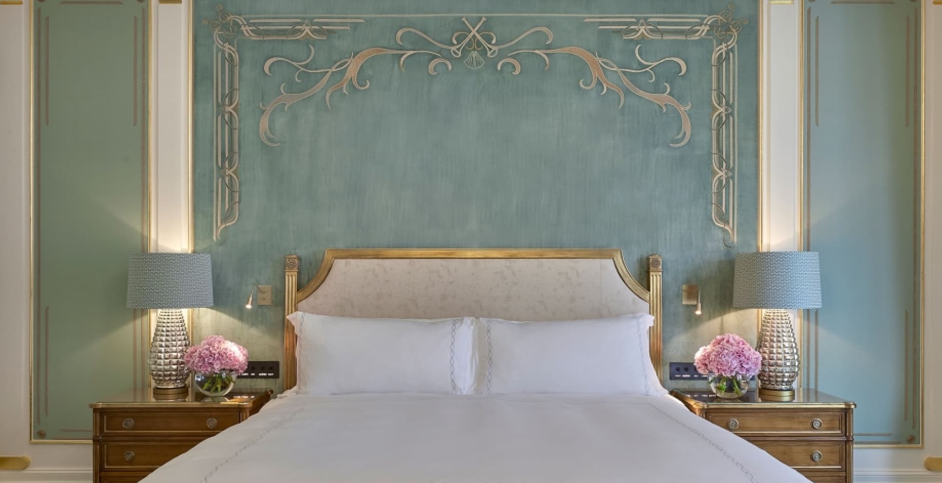 Prince Alexander suite bedroom with upholstered headboard and seafoam green wall panels